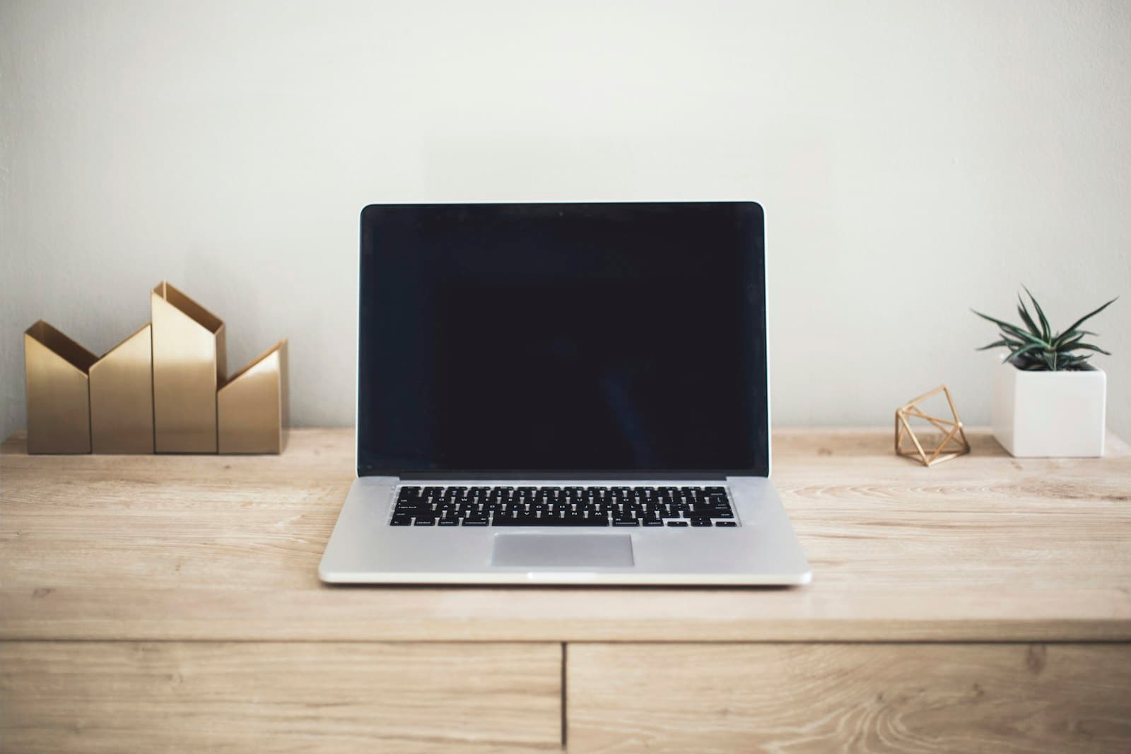 Premium Schreibtisch-Arbeitsplatz mit MacBook in warmem Licht als Sinnbild für JB Studios Designanspruch